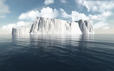 an iceberg floating in the middle of the ocean under a blue sky with clouds