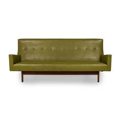 a green couch sitting on top of a wooden frame