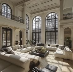 a large living room with lots of windows and couches in it's center