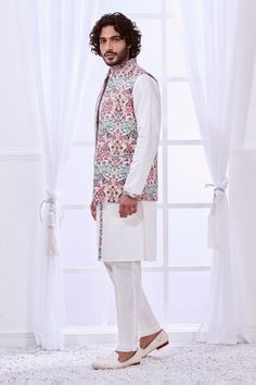 White Nehru jacket with thread embroidery in floral pattern. - Aza Fashions Spring Wedding Cotton Sherwani, Traditional Floral Print Bandhgala For Spring, Traditional Spring Bandhgala With Floral Print, White Sleeveless Nehru Jacket With Resham Embroidery, Spring White Nehru Jacket With Floral Print, Wedding Nehru Jacket With Floral Print, White Sherwani With Chikankari Embroidery For Spring, Spring White Sherwani With Chikankari Embroidery, Floral Print Fitted Nehru Jacket For Wedding