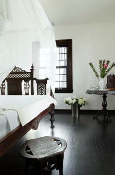 a bedroom with white walls and wood floors