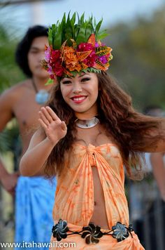 a woman in an orange dress with flowers on her head and two men behind her