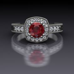 a ring with a red stone surrounded by white diamonds on a reflective surface in front of a black background