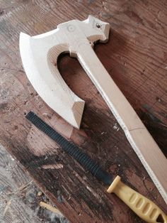 a woodworking tool is laying on the floor next to a hammer and pliers