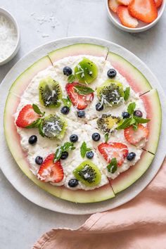 a watermelon pizza topped with kiwis, strawberries and blueberries