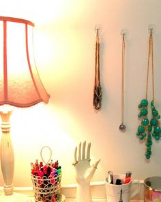 a desk topped with lots of jewelry and a lamp