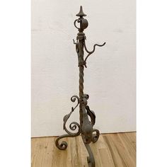 an iron candle holder on a wooden floor