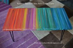 a rainbow colored table with hairpink legs on carpeted floor next to rug