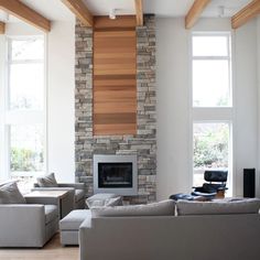 a living room with two couches and a fire place in the middle of it