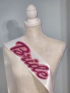 a mannequin wearing a white dress with pink sequins and the word bride on it