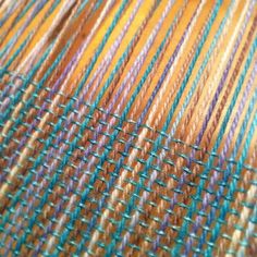 close up view of multicolored yarn on the loom, with blurry lines