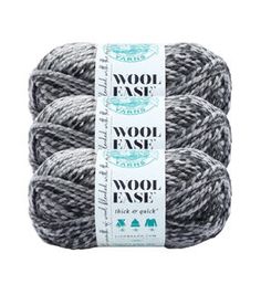 three skeins of wool ease yarn in grey and white