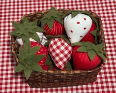 a basket filled with red and white strawberries on top of a checkered table cloth