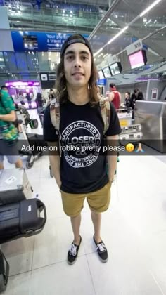 a young man standing in an airport with his luggage on the carousels behind him