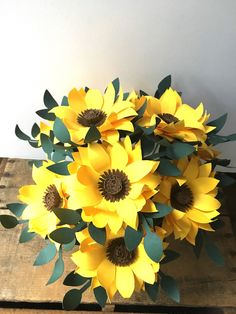 a bouquet of yellow flowers sitting on top of a wooden table