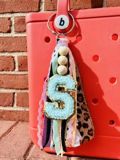 a keychain hanging on the side of a brick wall with a number 5