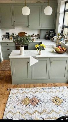 a kitchen with an area rug on the floor and cabinets in front of the counter