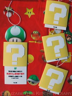 paper mario birthday party decorations on a red tablecloth with question mark and other items