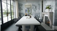 a dining room table with black chairs and a fireplace in the backround area