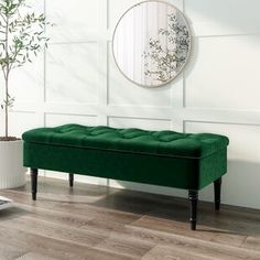 a green bench sitting in front of a white wall with a mirror on the wall