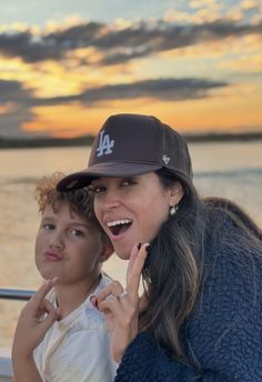 a woman and child on a boat at sunset