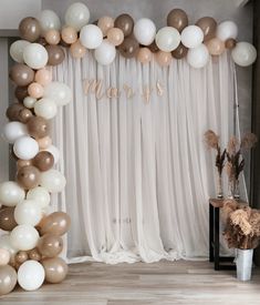 the balloon arch is decorated with gold, silver and white balloons