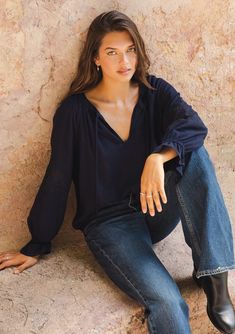 [Color: Navy] A lifestyle image of a brunette model wearing a bohemian navy blue blouse. With a split v neckline Chic Flowy Rayon Peasant Top, Chic Relaxed Fit Peasant Top For Fall, Relaxed Fit Peasant Top For Fall, Fall Rayon Peasant Top, V-neck Relaxed Fit Peasant Top For Fall, Casual Flowy Peasant Top For Fall, Fall V-neck Relaxed Fit Peasant Top, Relaxed Fit V-neck Peasant Top For Fall, Spring Bohemian Tops For Casual Gatherings