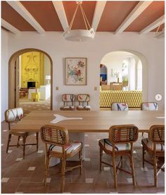 a large dining room table and chairs with an archway in the middle between them to another room