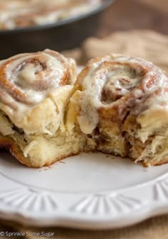 two cinnamon rolls sitting on top of a white plate