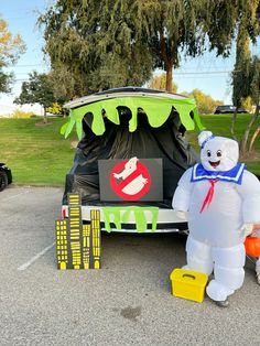 a large inflatable bear standing next to a car