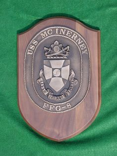 a wooden plaque with the seal of an officer's office on it, mounted on a green cloth