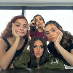 four young women are posing for the camera