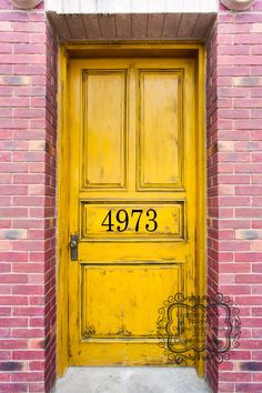 a yellow door with the words please remove shoes on it in front of a brick building