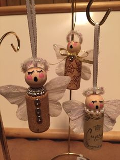 three little angel ornaments hanging from a hook