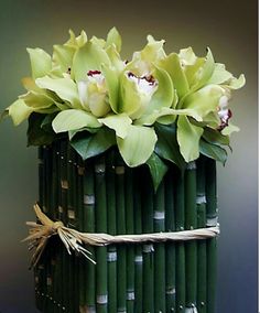 a green vase filled with flowers on top of a table