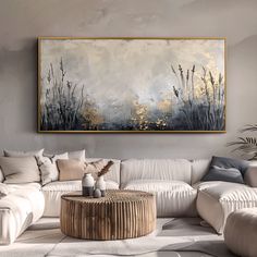 a living room filled with furniture and a large painting on the wall above it's coffee table