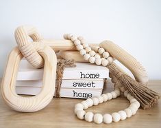 a wooden bead necklace and some books on a table with the words home sweet home