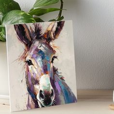 a painting of a donkey on a table next to a potted plant