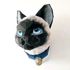 a paper sculpture of a cat with blue eyes