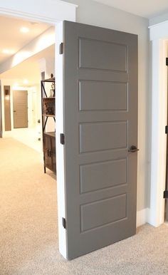 an open door in the middle of a room with carpeted flooring and white walls