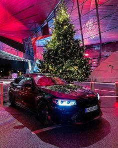 a car parked in front of a christmas tree