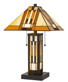 a lamp that is sitting on top of a wooden stand with a brown and yellow shade