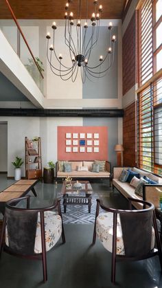 a living room filled with lots of furniture next to a tall wooden beamed ceiling