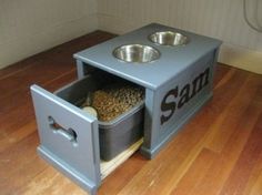 a dog food and water station with two bowls in it