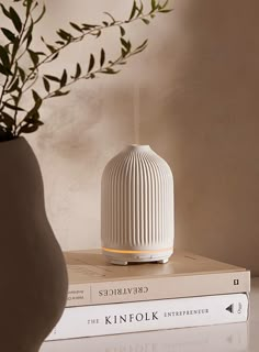 a white vase sitting on top of two books