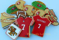 decorated cookies in the shape of football jerseys and mitts are shown on a blue background