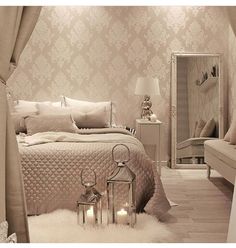 a bed room with a neatly made bed and two candles on the nightstands next to it