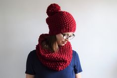 a woman wearing a red knitted hat and scarf