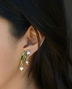 a close up of a person wearing some kind of earring with pearls on it