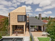 the house is made out of bricks and has a swimming pool in front of it